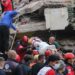 Rescuers and local volunteers carry a wounded victim on a stretcher from a collapsed building after a powerful earthquake struck Turkey's western coast and parts of Greece, in Izmir, on October 30, 2020. - A powerful earthquake hit Turkey and Greece on October 30, killing at least six people, levelling buildings and creating a sea surge that flooded streets near the Turkish resort city of Izmir. (Photo by - / IHLAS NEWS AGENCY / AFP) / Turkey OUT