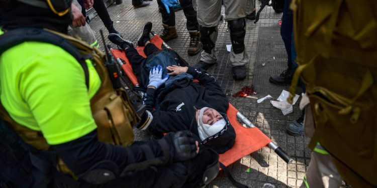 (FILES) In this file photo taken on May 01, 2022 medical staff treat a demonstrator injured during clash with riot police following a May Day march in Santiago on May 1, 2022. - Journalist Francisca Sandoval, who was shot while covering a confrontation on May Day in Santiago, died on May 12, 2022 after 12 days of hospitalisation. Sandoval was one of three people reached by bullets during the clashes. (Photo by Martin BERNETTI / AFP)