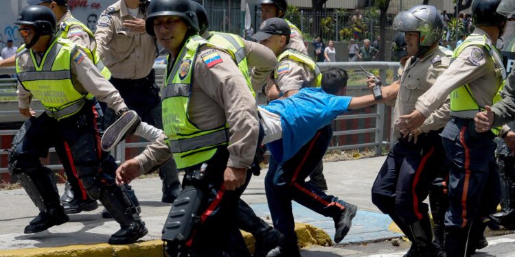 Police carry a demonstrator under arrest during a protest against President Nicolas Maduro's government in Caracas on April 4, 2017. 
Activists clashed with police in Venezuela Tuesday as the opposition mobilized against moves to tighten President Nicolas Maduro's grip on power. Protesters hurled stones at riot police who fired tear gas as they blocked the demonstrators from advancing through central Caracas, where pro-government activists were also planning to march. / AFP PHOTO / FEDERICO PARRA