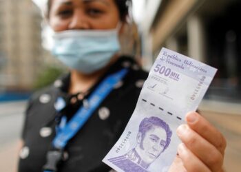 A woman shows a banknote of 500,000 bolivars, worth just 25 U.S. cents at the current exchange rate, in Caracas, Venezuela March 16, 2021. REUTERS/Leonardo Fernandez Viloria NO RESALES. NO ARCHIVES