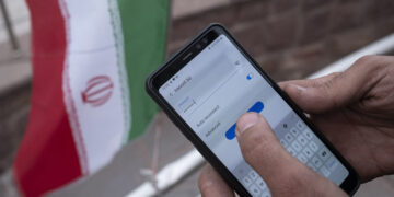 An Iranian park guard enters password on his smartphone as he tries to connect to an Irancell 5G network through the Huawei modem in northern Tehran on February 16, 2021. Irans first 5G network has ran by the Irancell company which is an Iranian telecommunications company that operates Iran's largest 2G-3G-4G-4.5G also 5G mobile network, and fixed wireless TD-LTE internet services. (Photo by Morteza Nikoubazl/NurPhoto via Getty Images)